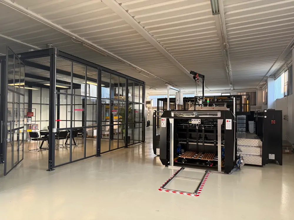 Interior of Jinbao Europe Pesaro showroom with screen printing machine and glass-partition meeting room